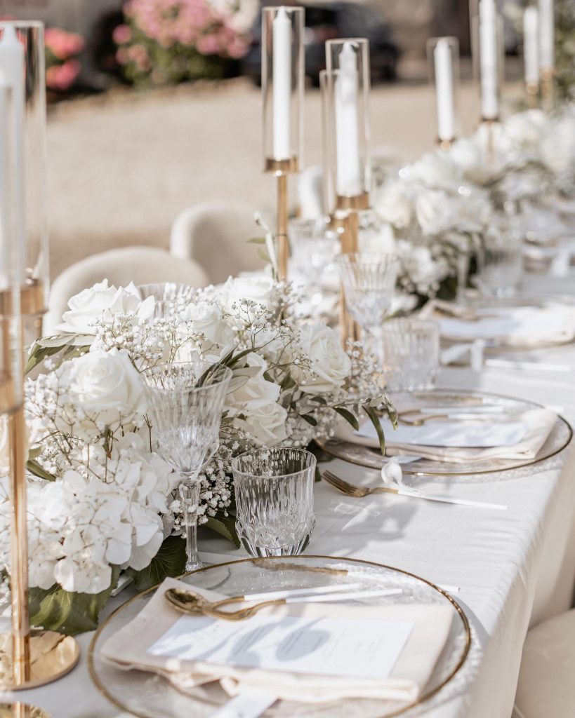 Eine Tischdekoration mit weißen Blumen und goldenen Akzenten. Perfekt für eine elegante Veranstaltung.