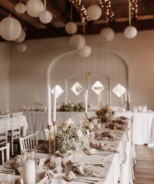 Eine Tischdekoration mit weißen Blumen und goldenen Akzenten. Perfekt für eine elegante Veranstaltung.